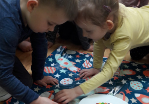 Dzieci układają cukierki na talerzu